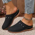 Close-up of stylish black women's mules featuring decorative cutouts and thick soles - 36 / Black