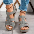 Dettaglio ravvicinato di sandali con zeppa grigi con eleganti motivi traforati laser - Grigio
