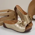 Detailed shot of golden platform wedge sandals with 3D flower and perforated pattern - Gold