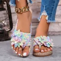 Gedetailleerde opname van kleurrijke plateau sandalen met bloemen en gevlochten bandjes. - Roze