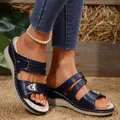 Detailed close-up of navy blue wedge sandals with metal buckles and decorative stitching - Dark Blue