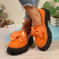 Stylish bright orange patent leather platform loafers featuring a large decorative bow - 36 / Orange