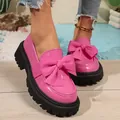 Close-up of stylish pink patent leather platform loafers with oversized bow detailing - 36 / Pink