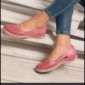 Vue détaillée de mocassins compensés roses évidés avec un jean bleu sur l'escalier - Rouge