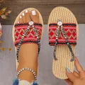 Detalle de las chanclas boho de paja con tiras bordadas rojas y adornos de flores - 36 / Rojo