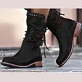 Close-up detail of black mid-calf boots featuring rear lacing design and metal stud accents - 36 / Black