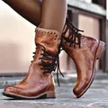 Detailed view of vintage brown leather lace-up ankle boots featuring rivet accents - 36 / Brown