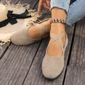 Détail de ballerines en daim beige avec des brides croisées élastiques sur un sol en bois. - 36 / Kaki