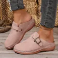 Close-up of pinkish-tan suede closed-toe mules with decorative stitching and buckle. - 36 / Pink