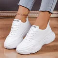 Close-up of stylish white platform sneakers with lace-up design worn on wooden floor - 35 / White