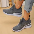 Primer plano de zapatillas de cuña grises con tejido fly-knit y adornos de cristal - Gris