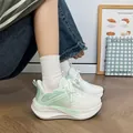 Detailed side view of women's chunky white and green breathable sneakers on model - 35 / Green
