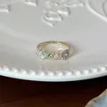 Gedetailleerde weergave van een verstelbare open ring met pastelbloemen en glinsterende details. - Blauwe Bloem Ring