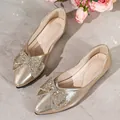 Elegant gold pointed-toe flat with sparkling rhinestone bow detail on a marble surface. - 35 / Bow Rhinestone Flats (A88) / Gold