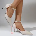 Close-up of elegant cream pointed-toe heels featuring a 6.5cm stiletto and pearl strap - Beige