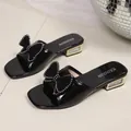 Elegant black patent leather chunky heel slide sandals featuring a studded bow detail - 36 / Black