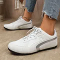 Gros plan de baskets blanches pour femmes avec rayures argentées et semelle en caoutchouc - 36 / German Trainer (B13) / Blanc