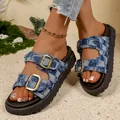 Close-up of women's stylish denim platform sandals featuring double gold buckles and frayed edges - Denim Blue