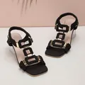 Stylish black elastic strap sandals with geometric gold accents and clear block heels. - 36 / Black
