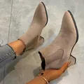 Macro view of suede Chelsea boots showing the block heel and elegant pointed toe design - Khaki
