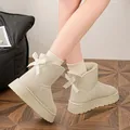 Close-up of stylish beige thick-soled snow boots featuring a cute bow detail on the back - 36 / Off White