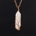 Close-up detail of a handmade copper wire wrapped tree of life pendant on a white crystal - White Crystal