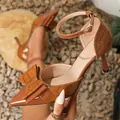Detailed view of brown pointed high heels featuring a large bow and embossed texture. - 35 / Caramel color