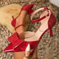 Detailed view of red crocodile-patterned stiletto heels with elegant bow decoration. - 35 / Burgundy