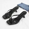 Macro view of black thong kitten heel sandals with square toe design - Black