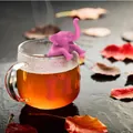 Pink elephant silicone tea infuser hanging on glass mug with autumn leaves background - Elephant