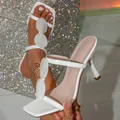 Primo piano di sandali bianchi con tacco alto e decorazioni ovali per la moda estiva. - 36 / Bianco