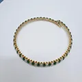 Close-up detail of a retro gold-plated choker with green and white marquise zircons. - White + Green
