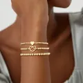 Set van drie stapelbare goudkleurige kralenarmbanden met hart- en knoopbedels. - Hart & Hart Knoop Armband Set (JZ-ZZ-019-11)