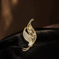 Gedetailleerde macro-opname van een gouden bladspeld met kristallen en witte parel - Parelblad Broche