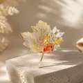 Detailed macro view of a luxury maple leaf brooch featuring vibrant orange and yellow crystals. - Maple Leaf Style (KC Gold Maple Orange Brooch) / Gold/Orange