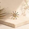 Primer plano de un broche de estrella dorada con pedrería brillante sobre piedra - Estilo Copo de Nieve (XZ0039)