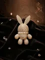 Detail van een fonkelende 3D-konijnenbroche met strass-steentjes en parelhalsband - Strass konijnenbroche - Goud