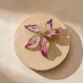 Close-up detail van een elegante paarse en roze emaille leliebloembloemsierproche - Paarse roosbroche