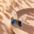 Close-up of elegant butterfly brooch featuring blue gradient crystals and golden frame. - Blue Crystal Butterfly Brooch