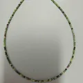 Detailweergave van gefacetteerde robijn-zoisiet kralenketting met vergulde accenten. - Rood-groene kralenketting / 38+5cm