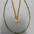 Gedetailleerd overzicht van groene kralenketting met gouden libel hanger. - Set van libel hanger halsketting en rood-groene kralenketting / 45+5cm