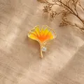 Exquisite gold-tone ginkgo leaf brooch with vibrant orange enamel and crystal detail - Hollow Enamel Yellow Ginkgo Leaf