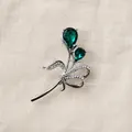 Macro-opname van een tulpenbroche met groene kristallen en glinsterende strass-steentjes - Zilveren Bloem Brosche