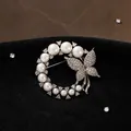 Elegant silver-toned circular brooch featuring white pearls and a crystal-set butterfly. - Ring Butterfly Pearl Style (BH08-Silver)