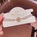 Elegant double-strand pearl bracelet with a sparkling zircon star center on a card - Starburst Zirconia Double Layer Artificial Pearl Style