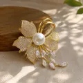 Detailopname van een luxe gouden bloembloesem broche met grote parel en kristallen - Sparkling Strass Parel Broche