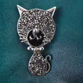 Broche chat stylisée avec cristaux gris et émail noir sur fond vert texturé - Chat en Strass Noir