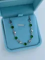 Bracelet cœur argenté élégant avec cristaux verts éclatants dans un écrin de bijoux bleu clair - Bracelet Cœur / Green Zirconia