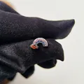 Vista macro di un orecchino a lobo arcobaleno con pietre rosa e blu su guanto. - Arcobaleno Amore-Pezzo Singolo (Y184)