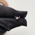 Vista macro di un piercing alla cartilagine in acciaio chirurgico con stella rosa e argento - Stella Traforata-Pezzo Singolo (Y187)